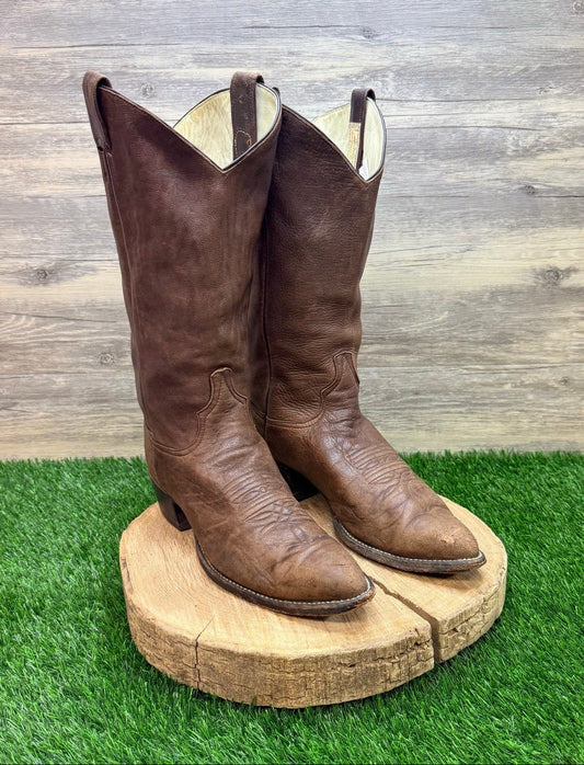 Pair of brown cowboy boots on grass